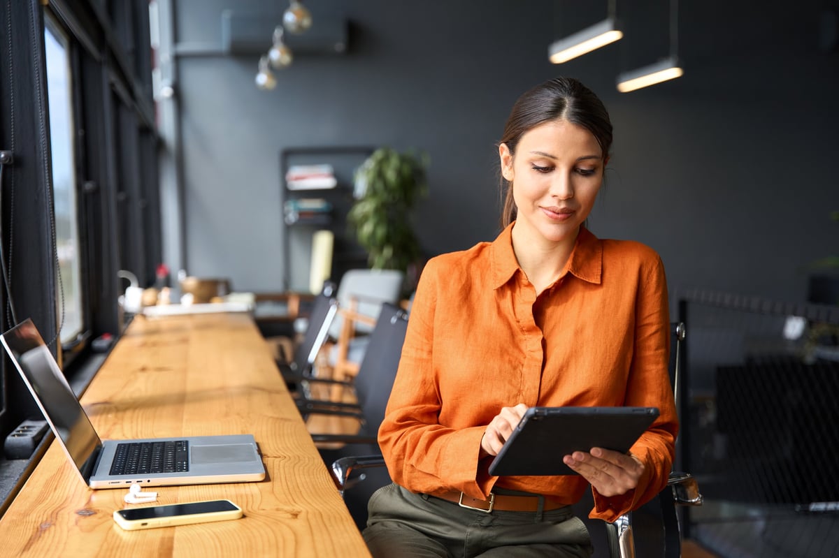 Successful smiling businesswoman professional holding digital tablet for work in modern office workplace