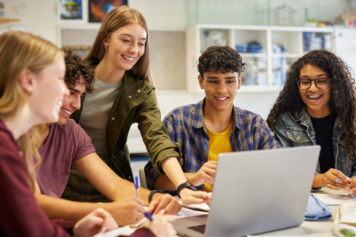 Multiethnic casual students using laptop during research, working together on a project