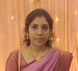 Woman wearing purple and pink saree with gold necklace